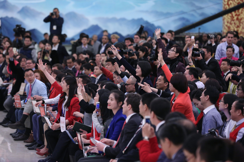 3月15日，國務院總理李克強在北京人民大會堂與中外記者見面，并回答記者提問。這是記者舉手爭取提問機會。 新華社記者 才揚 攝