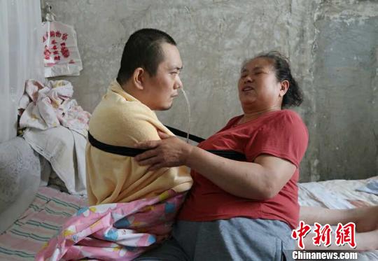 身體日漸衰老的梁青蘭每次幫兒子翻身、坐立，全身的衣物都要濕透一次?！∩忻鱾b 攝