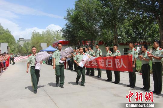 部隊(duì)官兵們迎接出院歸來的李運(yùn)飛(中)和其他消防戰(zhàn)士?！⊥粲?攝