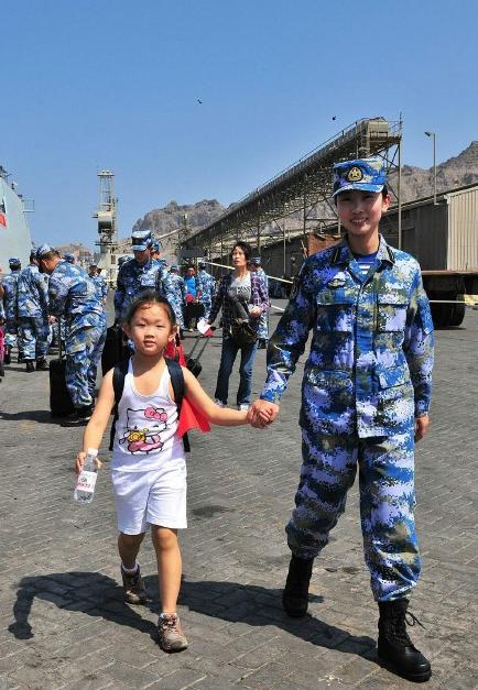 2015年3月，也門，海軍女戰(zhàn)士牽著一名小女孩的手準備登上軍艦。