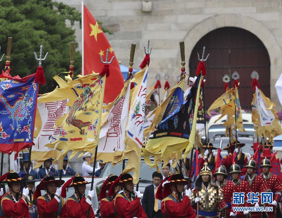 7月3日，韓國(guó)總統(tǒng)樸槿惠在青瓦臺(tái)總統(tǒng)府舉行隆重儀式，歡迎中國(guó)國(guó)家主席習(xí)近平對(duì)韓國(guó)進(jìn)行國(guó)事訪問(wèn)。這是習(xí)近平的車隊(duì)在身著民族服裝的韓國(guó)禮儀隊(duì)伍引導(dǎo)下駛?cè)肭嗤吲_(tái)。新華社記者丁林?jǐn)z  